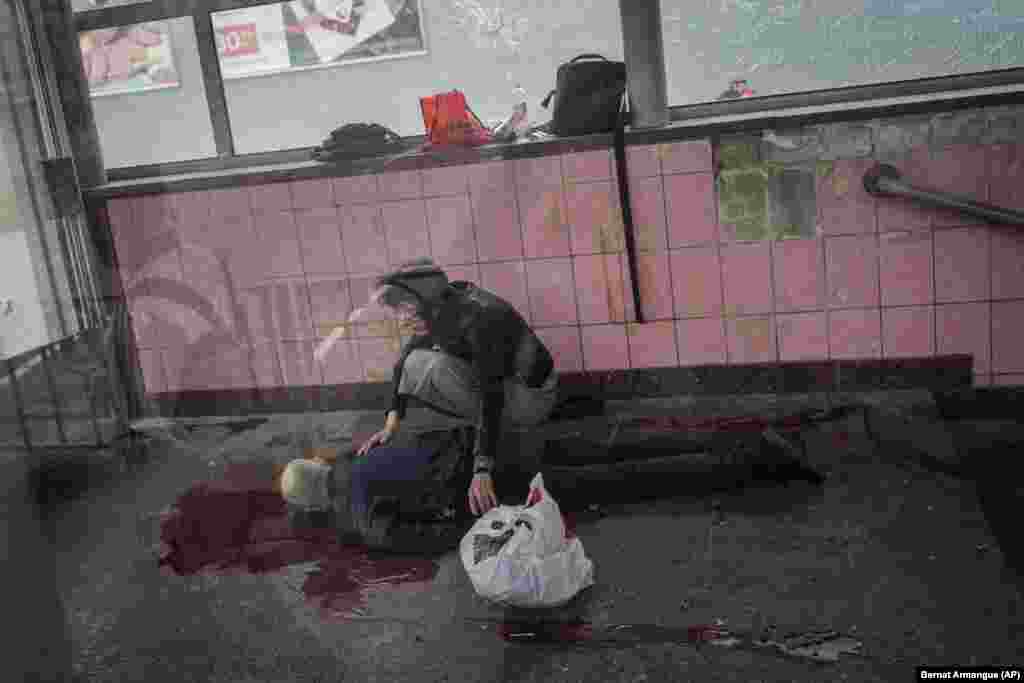A woman kneels next to the body of her husband, Oleksiy, who was killed during shelling of the eastern city of Kharkiv on May 26.&nbsp;