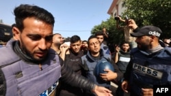 Палестински журналисти вървят в погребалната процесия за своя колега Хасан Аслих, убит при израелски удар срещу болница „Насер“ в Хан Юнис в южната част на ивицата Газа, 13 май 2025 г.