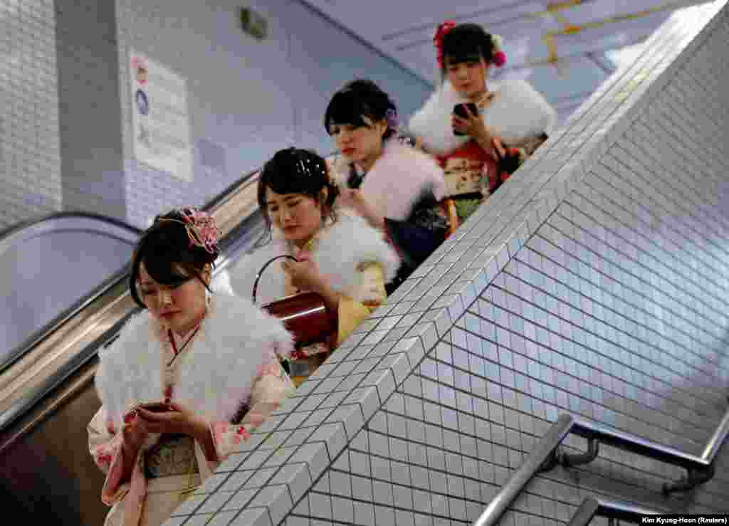 Japanese women wearing kimonos ride an escalator at a subway station after attending their Coming of Age Day ceremony in Tokyo. (Reuters/Kim Kyung-Hoon)