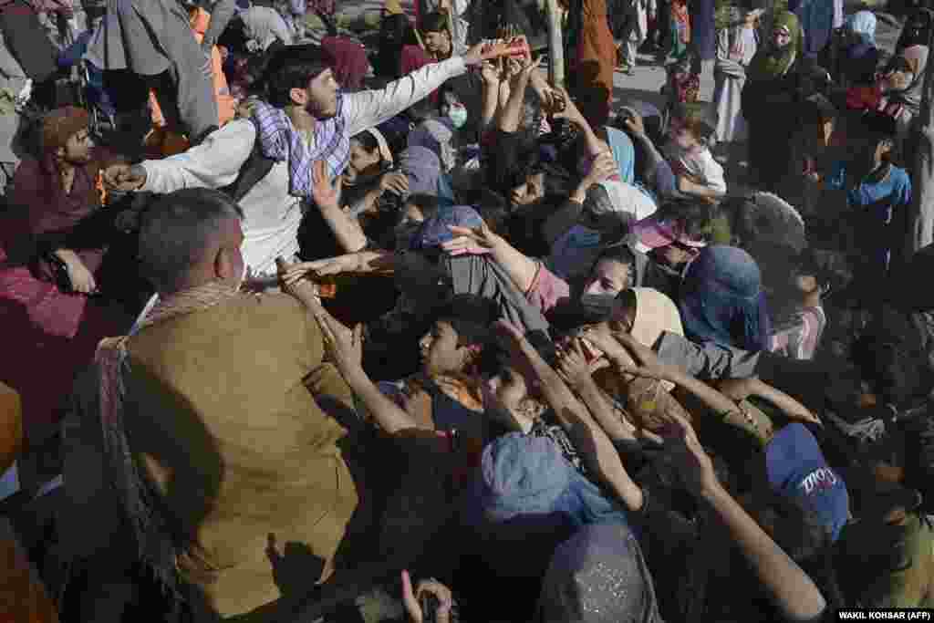 Displaced Afghans scramble for food in Kabul.