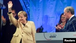 Angela Merkel îl susține la alegeri pe liderul Partidului Creștin Democrat, Armin Laschet, aici la o adunare electorală în orașul Stralsund, la 21 septembrie 2021. Dar favorit în cursa de duminică este candidatul social-democrat, Olaf Scholz.