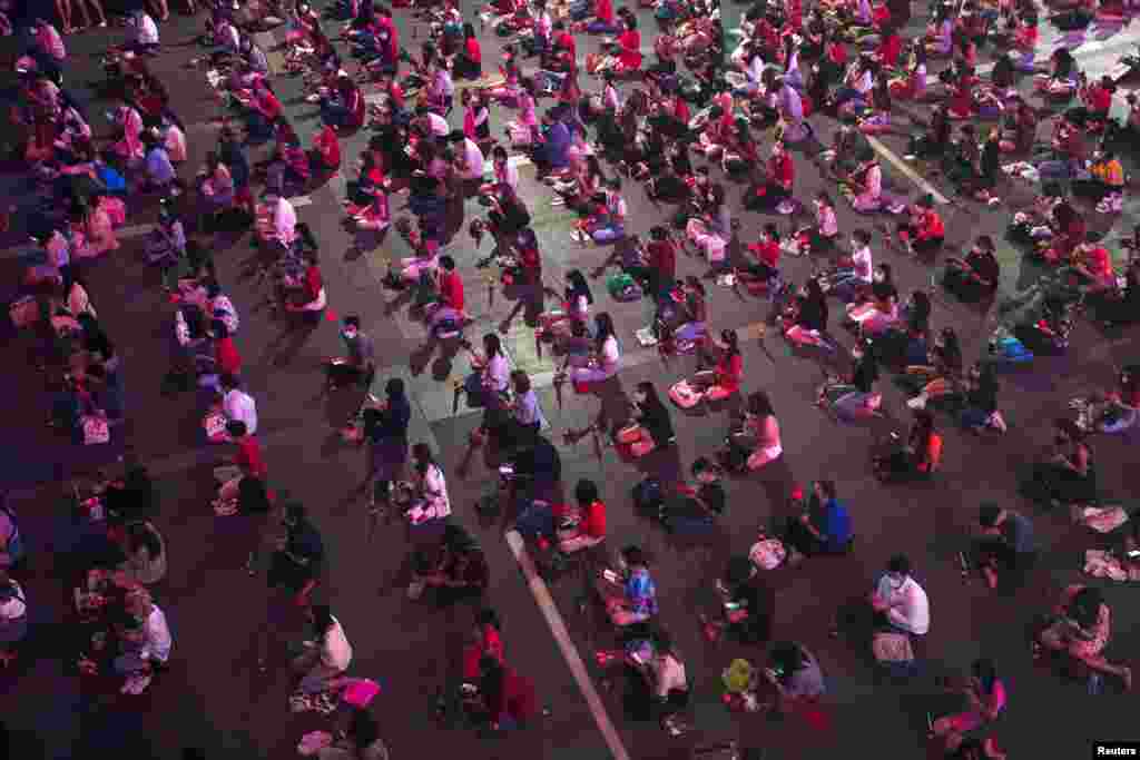 Люди моляться Богу любові під час релігійної церемонії у святині Пхра Трімурті в торговому районі Бангкока, щоб побажати удачі у пошуках споріднених душ до Дня святого Валентина вТаїланді, 11 лютого 2021 року
