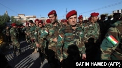 Kurdish Peshmerga fighters line up before voting for parliamentary elections in Iraq's Kurdish region outside a polling station in Irbil on September 28 as Kurdish armed forces voted ahead of the general public.