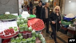 Iranians shop for fruit and vegetables in a market in northern Tehran on April 21, 2026.