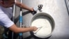 Një punëtor në një fabrikë të qumështit në Kosovë, gjatë kontrollit të produktit. 