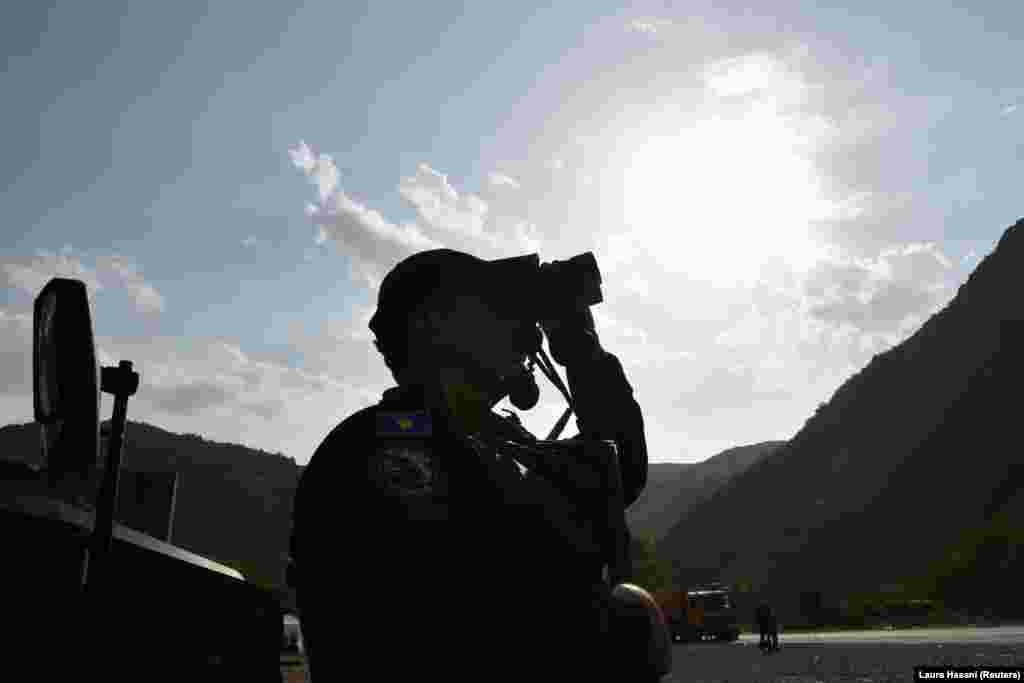 Një pjesëtar i njësitit special të Policisë së Kosovës duke vëzhguar me dylbi, në Jarinjë, në veriun e Kosovës. (27 shtator 2021)