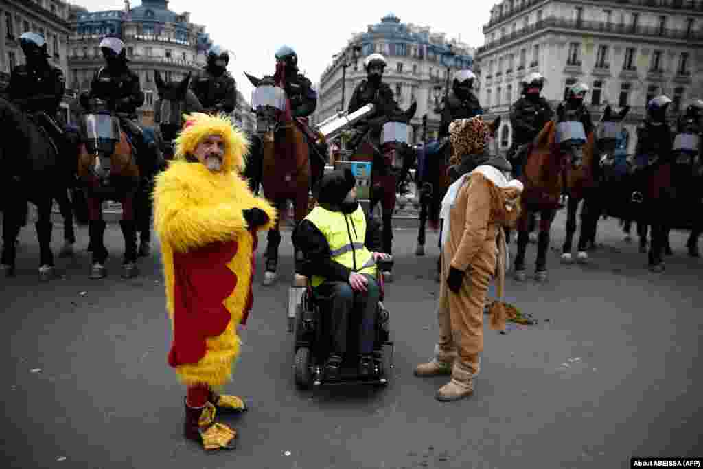 Protesters stand in front of mounted police during a demonstration in front of the Opera House in Paris against rising costs of living blamed on high taxes on December 15. (AFP/Abdul Abeissa)