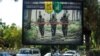 IRAQ -- A propaganda billboard for the pro-Iran Hizballah Brigades militia is seen hanging over Palestine Street in the centre of the Iraqi capital Baghdad, June 20, 2018