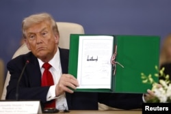 Дональд Трамп с текстом мирного соглашения, подписанного в Шарм-эш-Шейхе (Египет)
