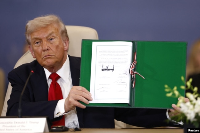 Donald Trump me tekstin e marrëveshjes së paqes të nënshkruar në Sharm el-Sheikh, Egjipt.