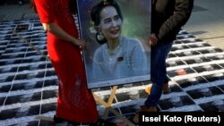 Protestatari afișând portretul lui Aung San Suu Kyi