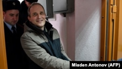 Dennis Christensen is escorted inside a courthouse following the verdict announcement in the town of Oryol in February 2019.