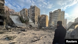 مردی در حال نظارهٔ ویرانه‌های برجای مانده از حملات هوایی اسرائیل به ضاحیه، حومه جنوبی بیروت