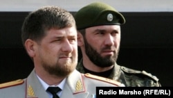 Magomed Daudov standing behind Chechen leader Ramzan Kadyrov
