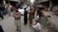 People stand outside their shops after a severe earthquake is felt in Rawalpindi, Pakistan, on January 31.