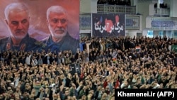 Supporters of the Iranian regime chant slogans during Friday Prayers in the capital Tehran, while a poster (R) proclaims "Death to America". January 17, 2020