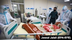 Afghan health workers carry the body of a coronavirus victim from the ICU ward at the Afghan-Japan Hospital for Covid-19 patients in Kabul on June 9.