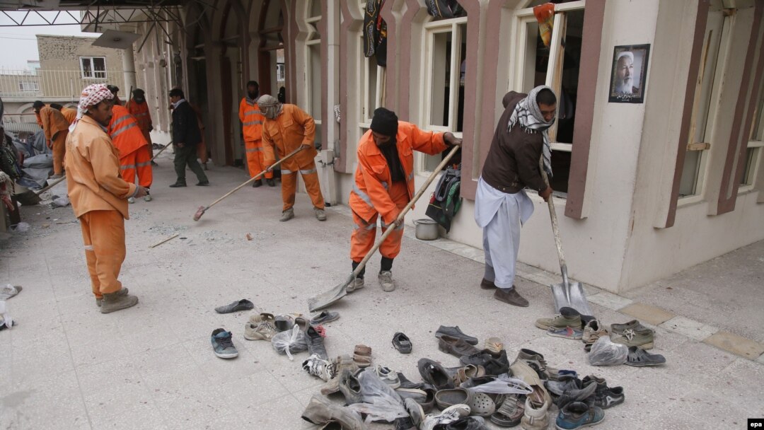 Workers clean the scene of a suicide bomb attack that targeted a Shi'ite mosque in Kabul on November 21 that killed at least 30 people. 