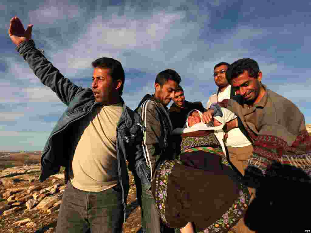 Palestinian men carry a woman who fainted after a confrontation with settlers and Israeli soldiers in the West Bank. - Photo by epa