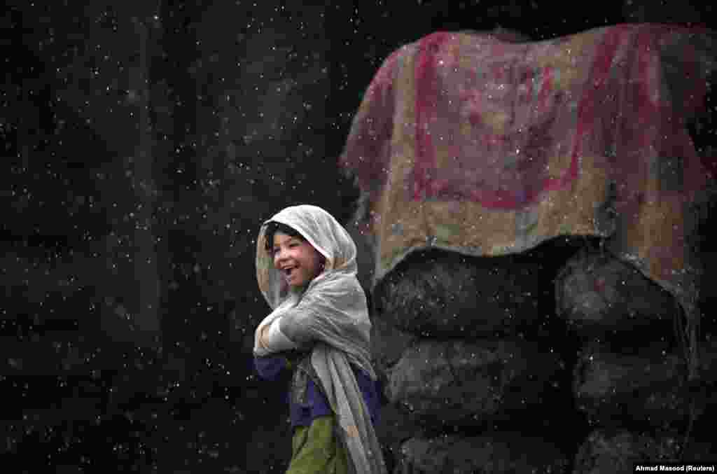 Девојче се смее додека паѓа снег. (Кабул, 13 јануари 2009 година)