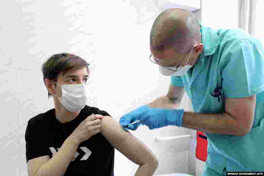 Serbian Prime Minister Ana Brnabic (left) receives a COVID-19 vaccine at the Institute of Virology, Vaccines, and Sera Torlak in Belgrade in a bid to boost public faith in vaccines as the country kicked off its immunization campaign on December 24. (AFP)