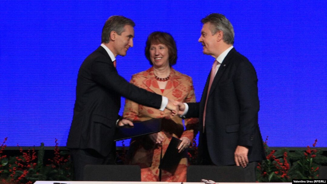 EU foreign policy chief Catherine Ashton looks on as Moldovan Prime Ministe Iurie Leanca (left) shakes hands with European Commissioner for Trade Karel de Gucht after the signing of an Association Agreement between Moldova and the European Union. 