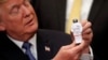 U.S. President Donald Trump holds an astronaut toy as he participates in a signing ceremony for the Space Policy Directive at the White House on December 11, 2017.