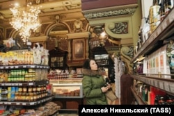 Žena pregledava dobro snabdjevene police prodavnice, 2006.