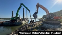 Bager tovari kamenje na baržu u mestu Izvoarele, Rumunija, 4. avgust 2026.