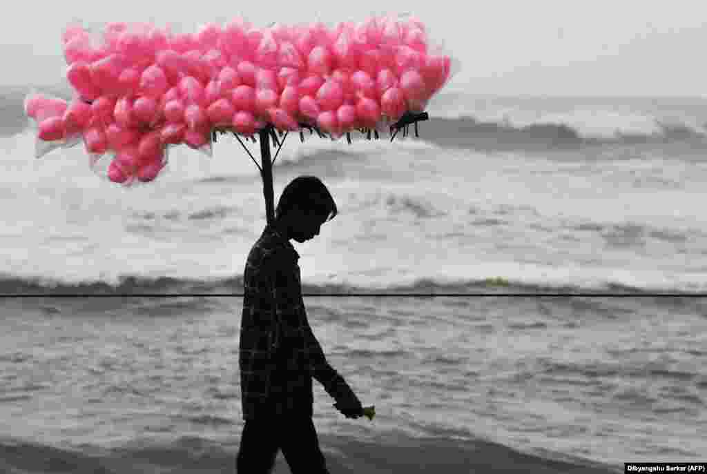 An Indian candy vendor walks along a closed beach in Puri in the eastern Indian state of Odisha as cyclone Fani approached the Indian coastline. Nearly 800,000 people in eastern India were evacuated ahead of a major cyclone packing winds gusting up to 200 kilometers per hour and torrential rains. (AFP/Dibyangshu Sarkar)