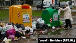 Жена хвърля боклук в кофа за разделно събиране в квартал "Люлин" в София.