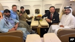 US citizen Amir Amiri (left) sits next to an unidentified woman aboard a plane in Kabul. With him (from right) are a Qatari diplomat; Sebastian Gorka, deputy assistant to the US president; and US special envoy Adam Boehler.