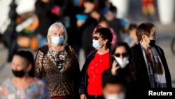 Disa gratë me maska ​​​​mbrojtëse ecin në Ashkelon, Izrael, 25 shkurt 2021. 
