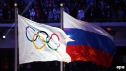 Russia -- The Olympic flag (L) and the Russian flag during the Closing Ceremony of the Sochi 2014 Olympic Games in the Fisht Olympic Stadium in Sochi, February 23, 2014