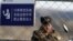 Түндүк Корея: Ялуцзян дарыясынын ортосундагы чек ара бекетинде турган аскер. 