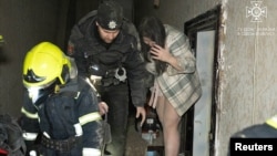 Rescuers evacuate a local woman from an apartment building hit by a Russian drone strike in Odesa on January 25.