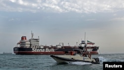 A boat of Iran's Islamic Revolutionary Guards Corps passes the Stena Impero, a British-flagged oil tanker that was seized by Iran in the Strait of Hormuz in July 2019 (file photo)