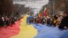 Участники протеста развернули флаг Молдовы на акции против нарушений на выборах президента. Кишинев, 14 ноября 2016 года