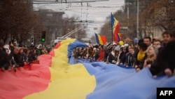 Участники протеста развернули флаг Молдовы на акции против нарушений на выборах президента. Кишинев, 14 ноября 2016 года