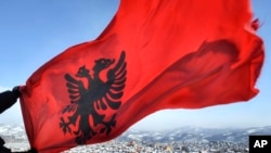 Футбольна асоціація Сербії попросила про видалення косовського журналіста, заявивши, що він спровокував сербських уболівальників, зробивши жест руками, що імітує двоголового орла на національному прапорі Албанії (на фото)