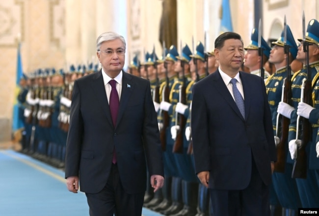 Президент Казахстана Касым-Жомарт Токаев и председатель КНР Си Цзиньпин проходят мимо почетного караула перед их переговорами в Астане, 3 июля 2024 года