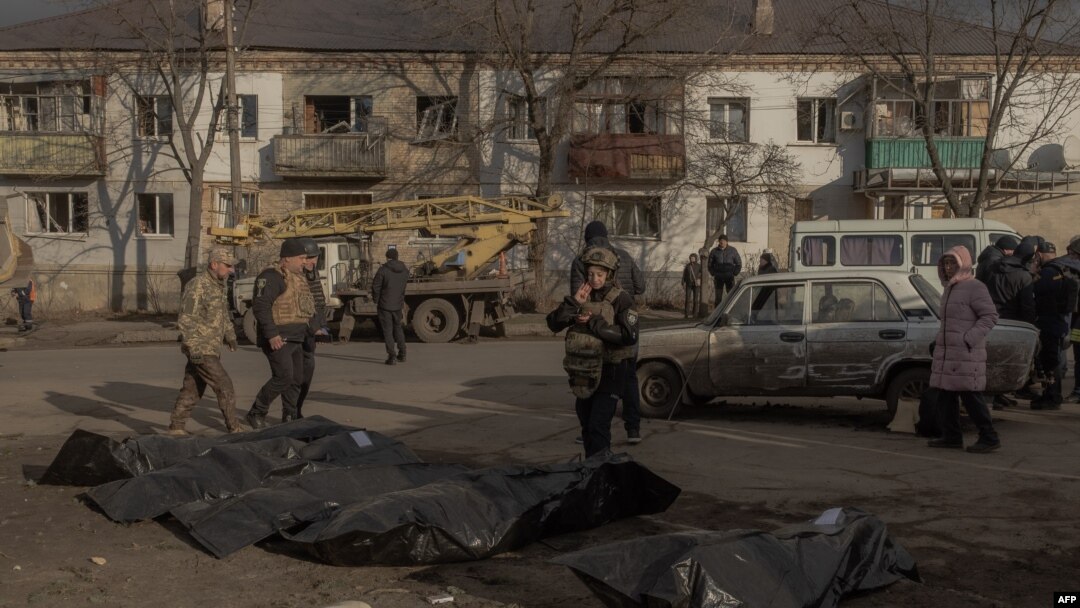 Un ofițer de poliție ucrainean inspectează cadavrele persoanelor ucise și puse în saci de plastic la locul unui atac rusesc cu rachete la Izium, Harkov - 4 februarie 2025.