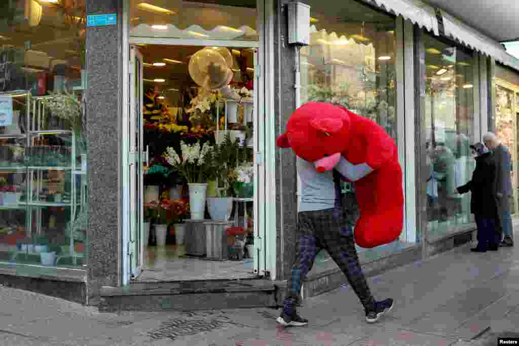Мужчина несет плюшевого медведя накануне Дня влюбленных в Тегеране, Иран, 13 февраля 2021 года