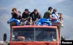 Refugees from Nagorno-Karabakh ride in a truck upon their arrival at the border village of Kornidzor, Armenia, on September 27.