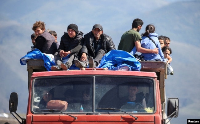 I rifugiati del Nagorno-Karabakh viaggiano su un camion al loro arrivo nel villaggio di confine di Kornidzor, in Armenia, il 27 settembre.