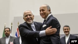 Iranian Foreign Minister Mohammad Javad Zarif (left) and French Foreign Minister Laurent Fabius react in Geneva to a landmark nuclear deal in Geneva.