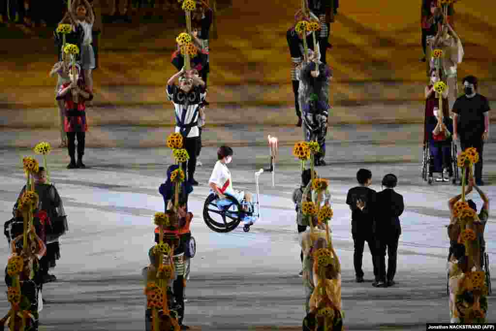 Факелоносец с олимпийским факелом на олимпийском стадионе во время церемонии открытия Олимпийских игр &mdash; 2020 в Токио, 23 июля 2021 года&nbsp;