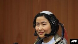 China -- Chinese People's Liberation Army (PLA) Air Force fighter pilot Liu Yang in her spacesuit posing for an official photo at the Jiuquan space base, 12Jun2012