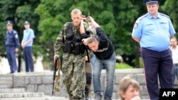 Проросійський бойовик веде чоловіка, підозрюваного в шпіонажі на користь українських військових, 21 червня 2014 року