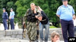 Пророссийский сепаратист ведет задержанного мужчину. Донецк, 21 июня 2014 года. Иллюстративное фото.